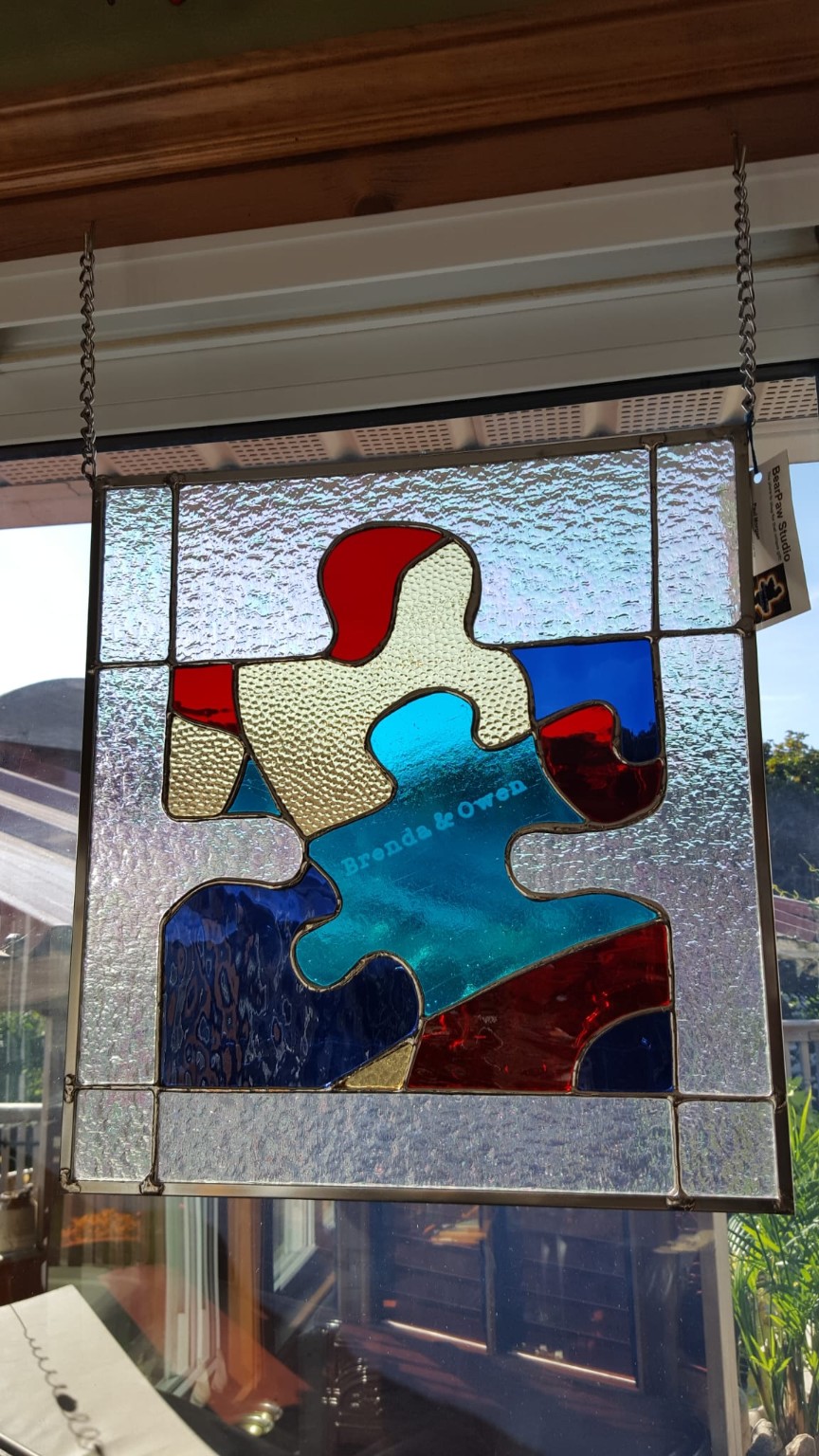 A colourful interlocking-puzzle stained-glass panel made as a personal commission