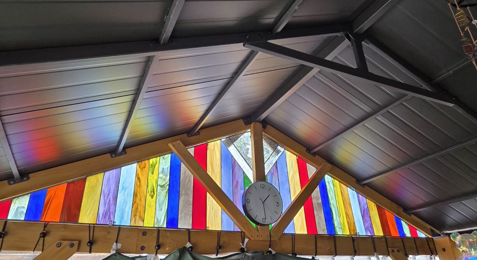 Triangular coloured-glass sections installed beneath a garden hot-tub roof